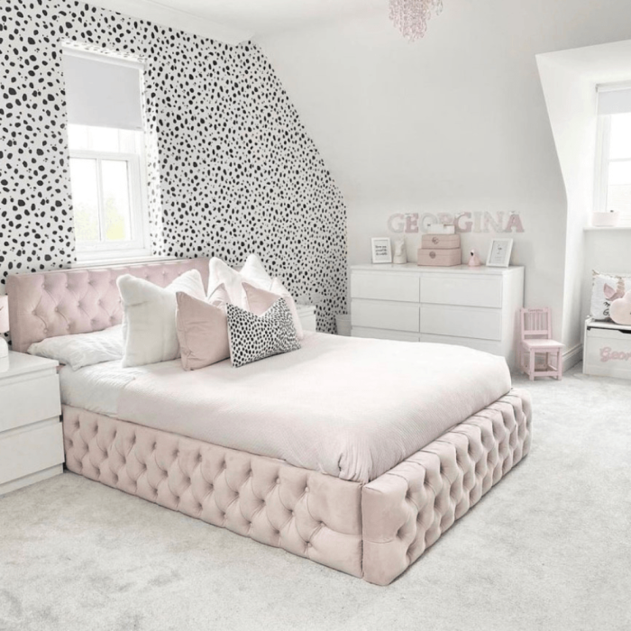 Blush pink bedroom with dalmatian wallpaper and a pink velvet bed
